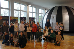 Uczniowie klasy 5 uczestniczący w pokazie Cyfrowego Planetarium Multimedialnego Planeta