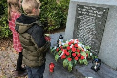 Uczniowie podczas  zapalania zniczy pod pomnikiem