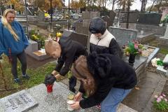 Uczniowie podczas  zapalania zniczy na cmentarzu